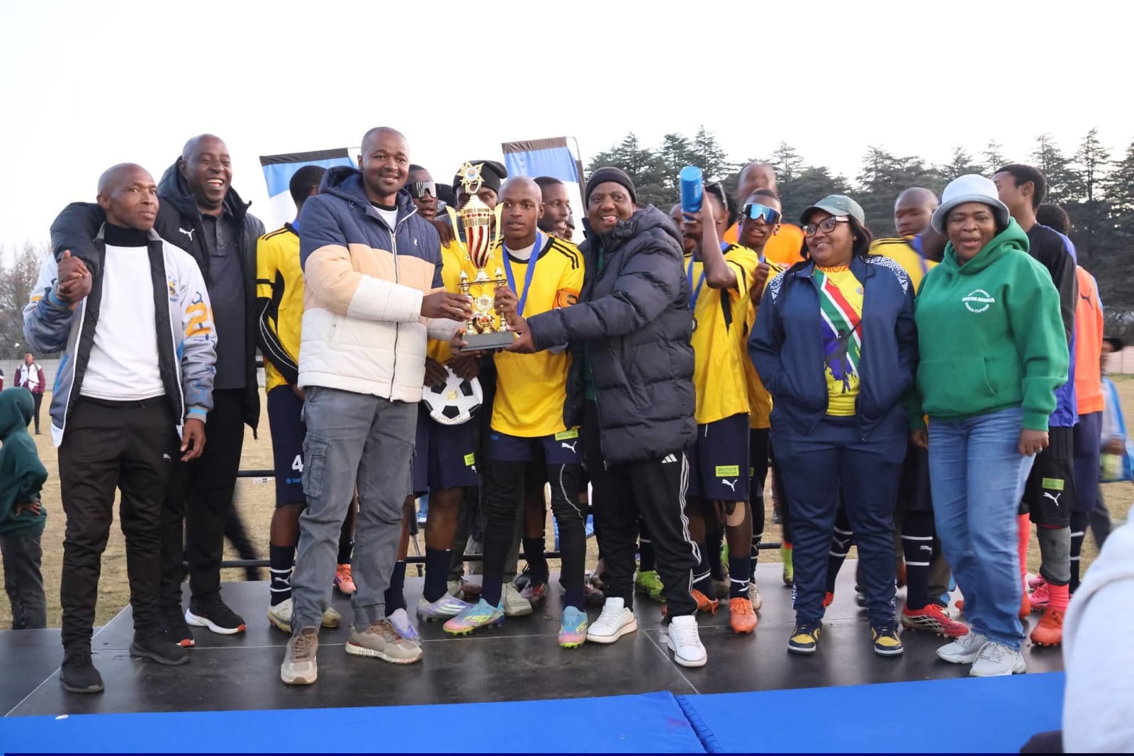 Ntsu SS soccer team receiving their winning trophy with Dihlabeng EM Tseki Tseki alongside them