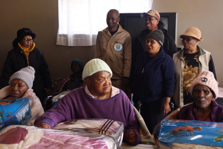 Dihlabeng Executive Mayor Tseki Tseki at Khabonina old age home handing over blankets to the elderly after planting peach trees